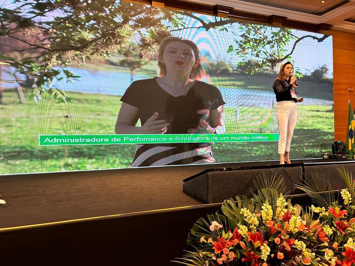 Palestra no palco, com a apresentação projetada no telão